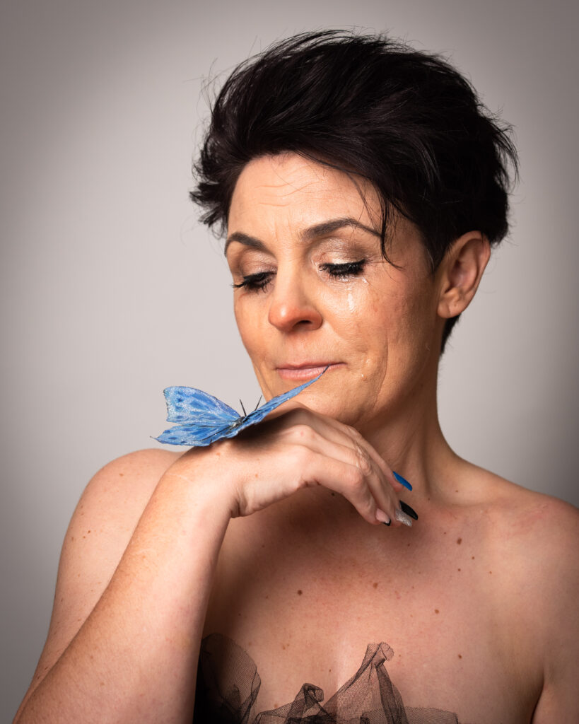 Jodie Atkinson with a blue butterfly resting on her hand