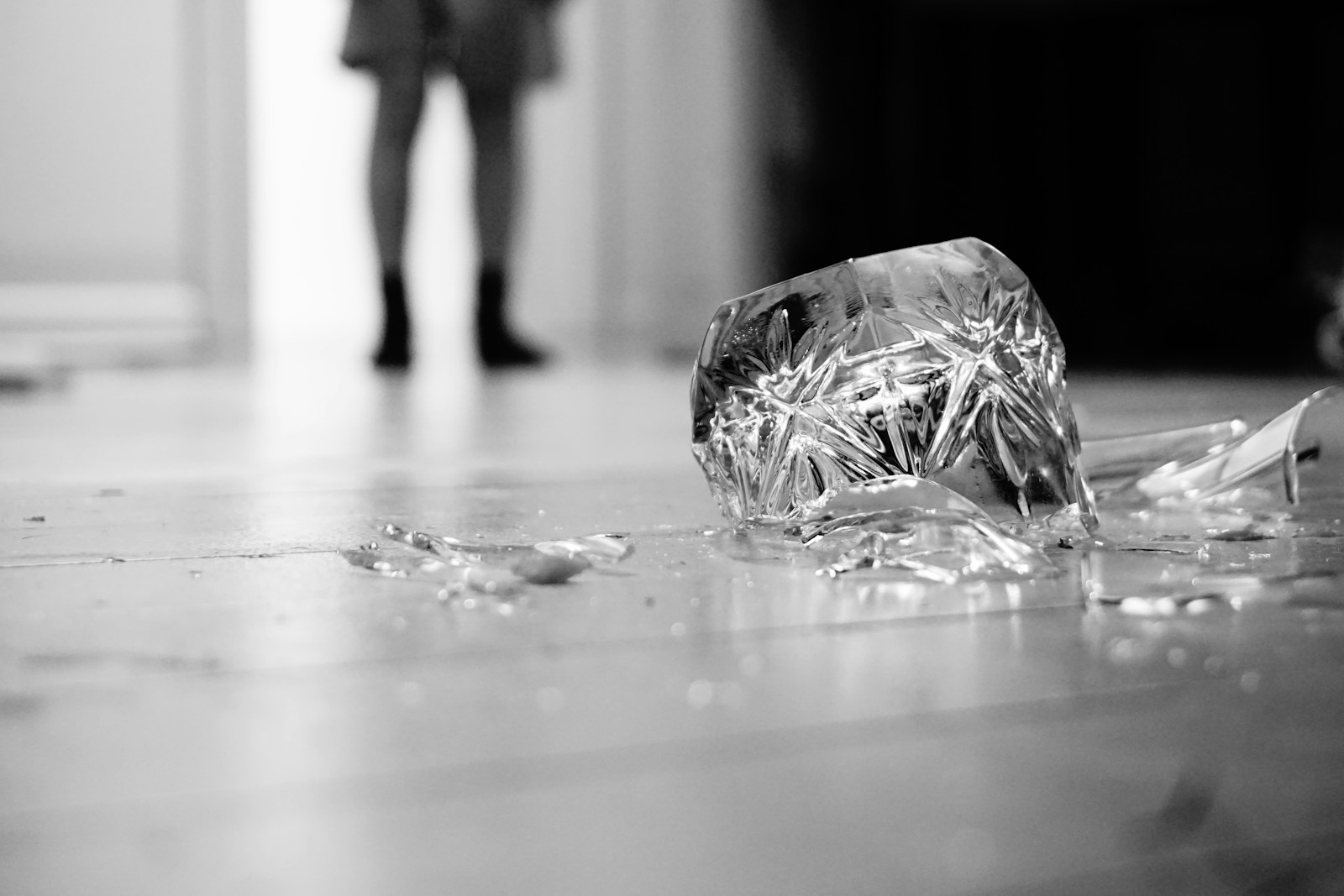 Shards of a broken glass scattered across a floor